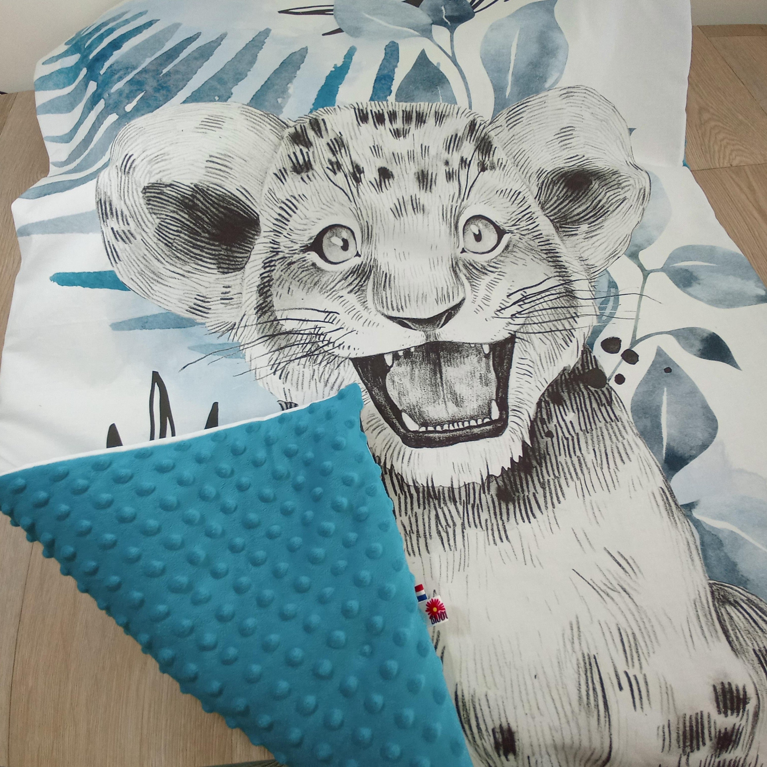Couverture bébé motif lionceau dans les tons de bleu